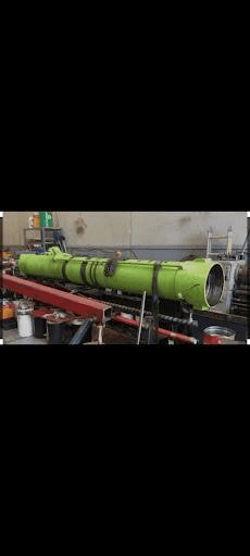 Custom green hydraulic cylinder on shop stands